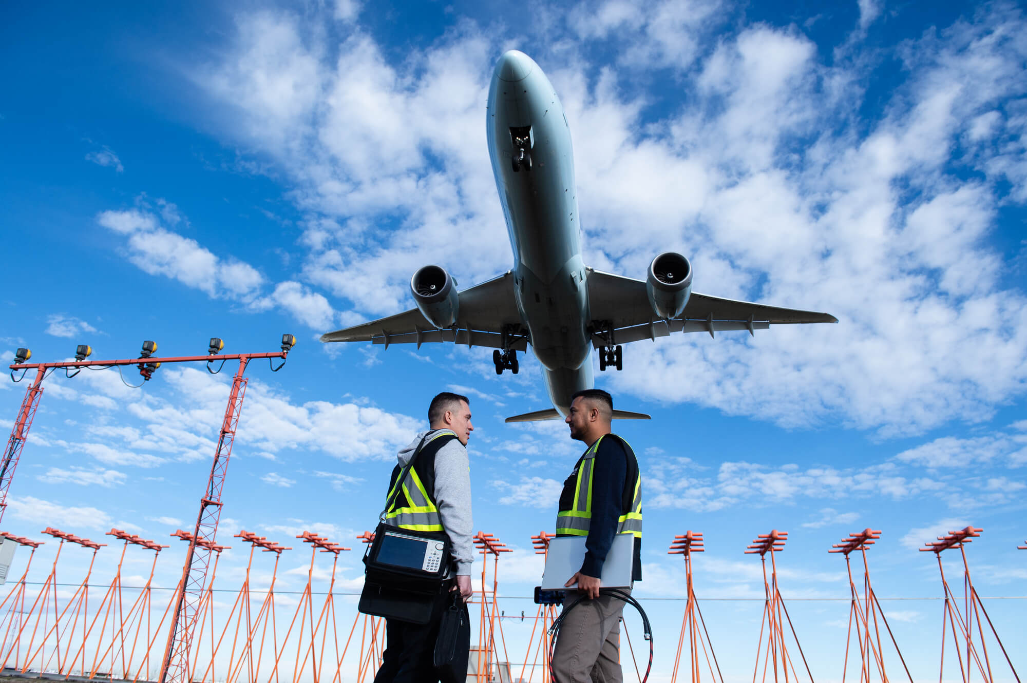 Two people talk to each other while a plane flies overhead